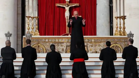 Reuters A priest giving instructions at the Vatican