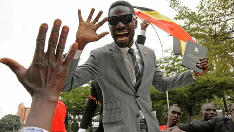 AFP Bobi Wine greets supporters