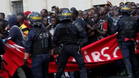 Reuters Undocumented migrants are surrounded by police after having occupied the Panthéon in Paris, 12 July 2019