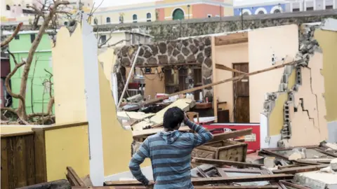 Getty Images Image shows damaged homes after Hurricane Maria made landfall on 21 September 2017 in San Juan, Puerto Rico