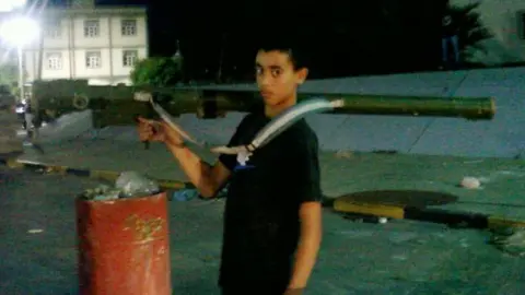 MAI Hashem Abedi carrying a rocket launcher