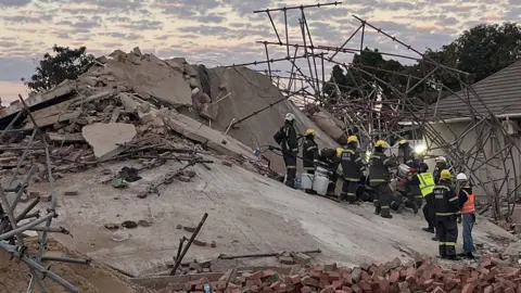 Getty Images Rescue workers on top of the collapsed building