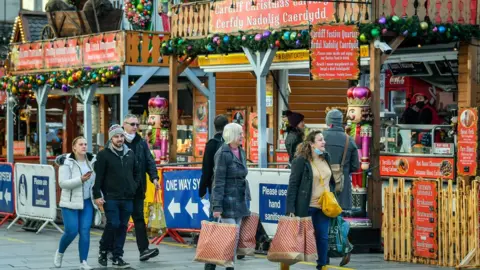 BBC Shoppers walking around the Cardiff Christmas Market food stalls