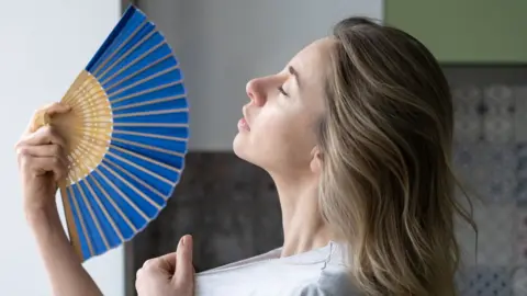 Getty Images woman trying to stay cool in the heat