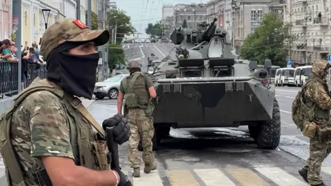 Reuters Fighters of Wagner private mercenary group stand guard in a street near the headquarters of the Southern Military District in the city of Rostov-on-Don, Russia, June 24, 2023.