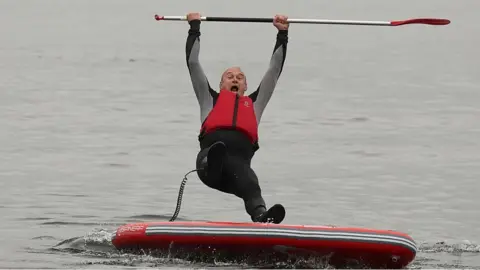 Ed Davey falls from a paddle board