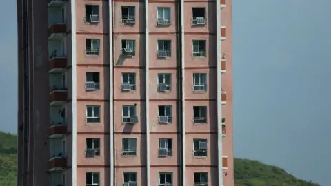 NK News Apartment bloc with several solar panes attached to windows