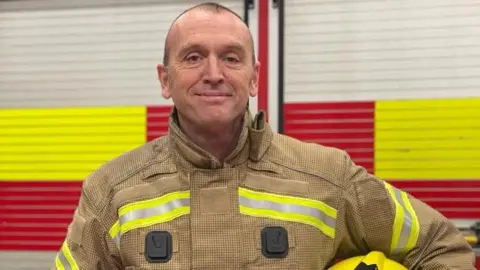 TWFRS A man in fire uniform smiles at the camera