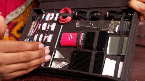 A box containing lots of science equipment including wires and batteries