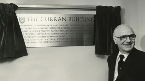 University of Strathclyde Archives OP/5/42/6 Sir Samuel Curran standing in front of the plaque at the building named in his honour