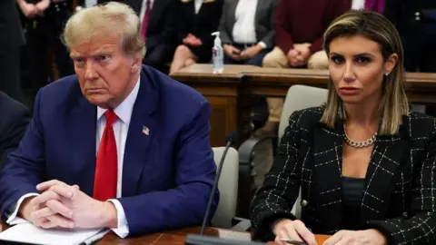 EPA File image of Alina Habba and Donald Trump sitting together in court