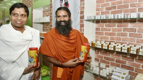 Getty Images Acharya Balkrishna and Baba Ramdev advertise Patanjali Ayurved