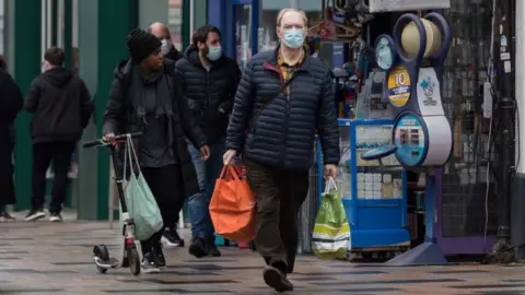 Getty Images Shoppers walking down a high street