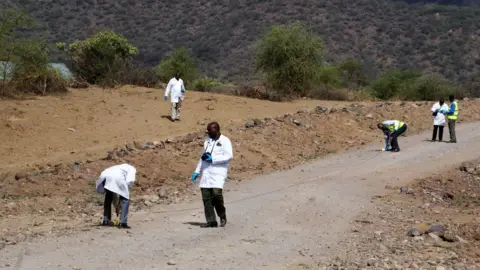 BBC/Peter Njoroge Forensic team searching a road
