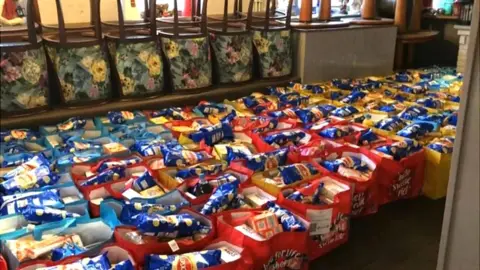 Martin Heath/BBC Several rows of parcels including crisps, breakfast cereals etc