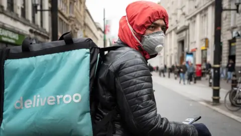 Getty Images Deliveroo driver wearing a mask in Cardiff, Wales