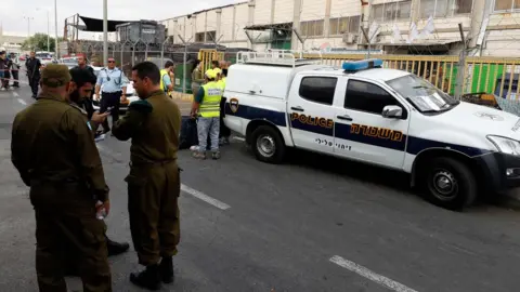 AFP Israeli security forces personnel stand outside the factory in the Barkan Industrial Zone, in the occupied West Bank, where two Israelis were shot dead on 7 October 2018