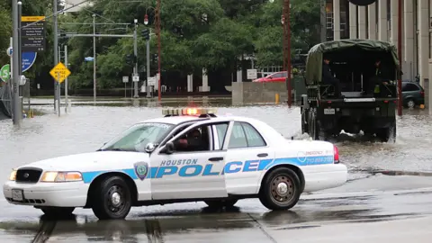 Getty Images Image shows a Houston Police vehicle in flood waters.