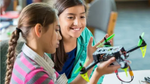 Getty Images Two young girls working on a drone