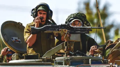 EPA Israeli soldiers aboard an armoured personnel carrier (APC) on patrol near the border with the Gaza Strip, southern Israel.