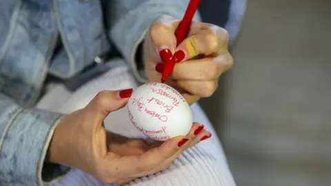 Getty Images A woman writes prayers on an egg at Ghriba Synagogue, Djerba, Tunisia - Friday 30 April 2021