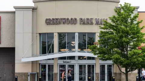 Getty Images A group of people wait outside of an entrance to Greenwood Park Mall on 18 July 2022