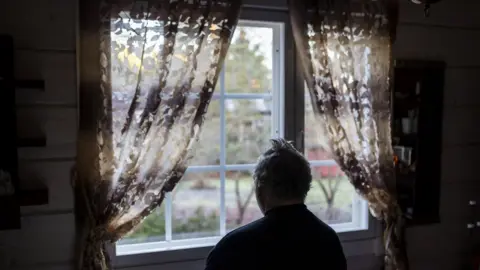 Getty Images A lonely man looking out of the window