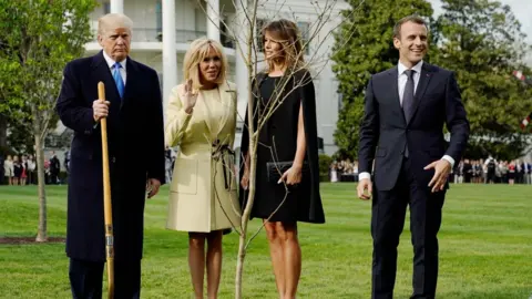 Reuters President Donald Trump, Brigitte Macron, Melania Trump and President Emmanuel Macron stand with the tree
