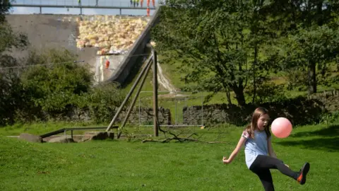 Jacob King/PA Wire Amelia Grace playing football with her grandparents Linda and Michael Darby