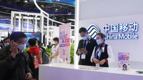 Getty Images People visit the stand of China Mobile Communications Group.