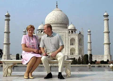 Getty Images Russian President Vladimir Putin speaks to his wife Ludmila as they pose in front of the Taj Mahal 04 October 2000