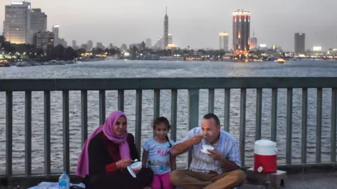 Getty Images A family eating on a bridge over the Nile River in Cairo Egypt