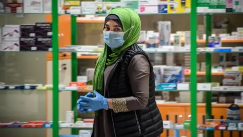 AFP Woman in face mask walks past Moscow pharmacy