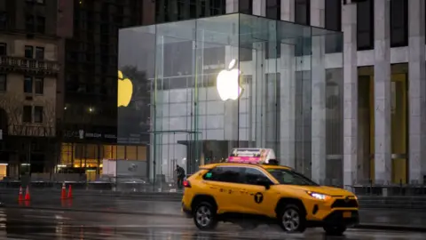 VIEW press / Getty Images A taxi drives past Appl's headquarters in New York