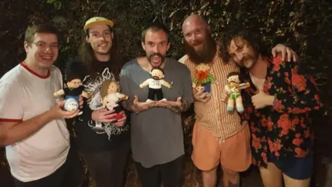 Annie Beavis/Idles Idles holding their mini-me dolls