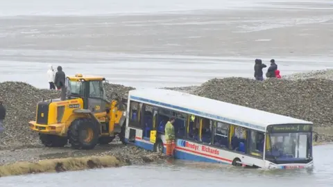 Wales News Service Photo of council workers clearing the road near the stranded bus in 2014