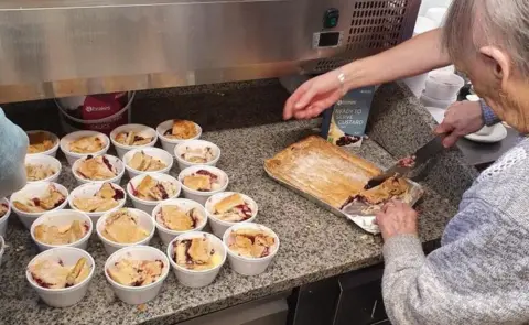 Les Nicoll Flo Osborne cutting up the pies she had made for the elderly and vulnerable