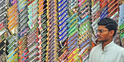 Getty Images An Indian man walks past a shop with magazines in different languages in Bangalore on July 1, 2009.