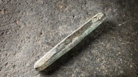A close-up of a silver ingot on floor