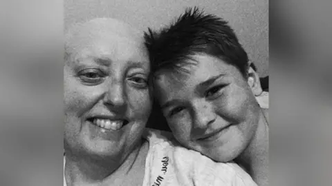 PA Media A black and white selfie of Jodie and her son. She is bald and they are leaning their heads together