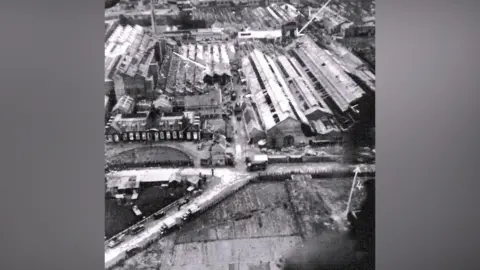 Shaun Noble Black and white photograph of the Ransome and Marles factory, a series of long, low buildings, with bomb damage highlighted