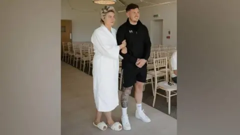 Kennedy News Ashleigh Stanley and childhood sweetheart Jake Stanley. They are dressed in casual clothes at their wedding 