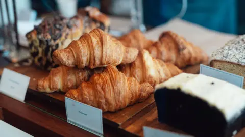 Getty Images Croissants and cakes lined up in a bakery window