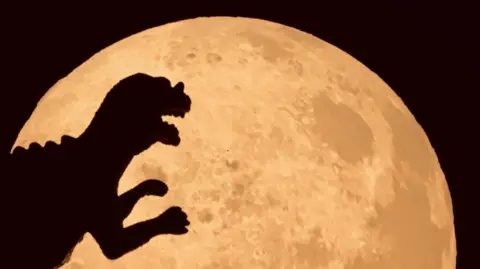 Dinosaur shadow on Moon above supermoon above Carnguwch, Gwynedd. 