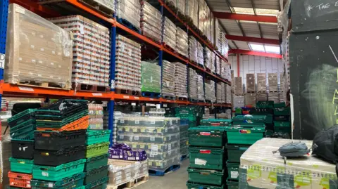 A warehouse full of pallets containing food and household items.