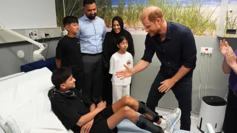 PA Media Prince Harry meets a young patient on a visit to support the WellChild charity