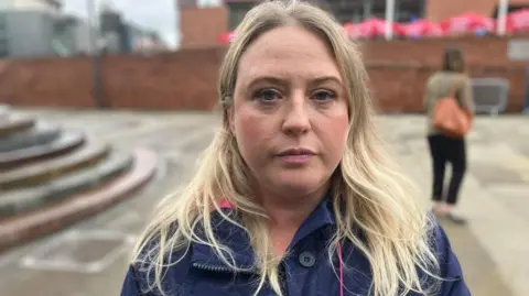 BBC / Kevin Fitzpatrick Kirby Hoyle stands outside the housing conference. She has long blonde hair and is wearing a blue jacket.