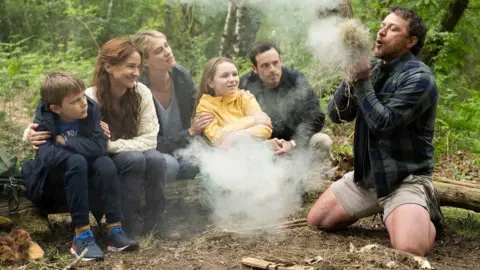 Universal Paddy, Ciara and their son Ant sit with the Daltons at the campfire