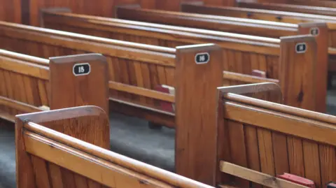 A stock image of wooden church pews.
