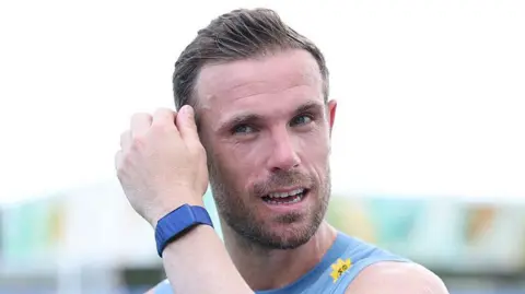 Jordan Henderson mops his brow during an England training session